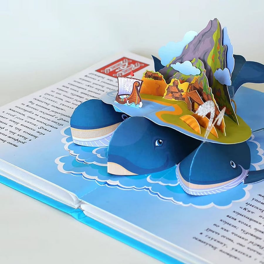 Colorful 3D pop-up scene featuring whales, island, and layered elements.